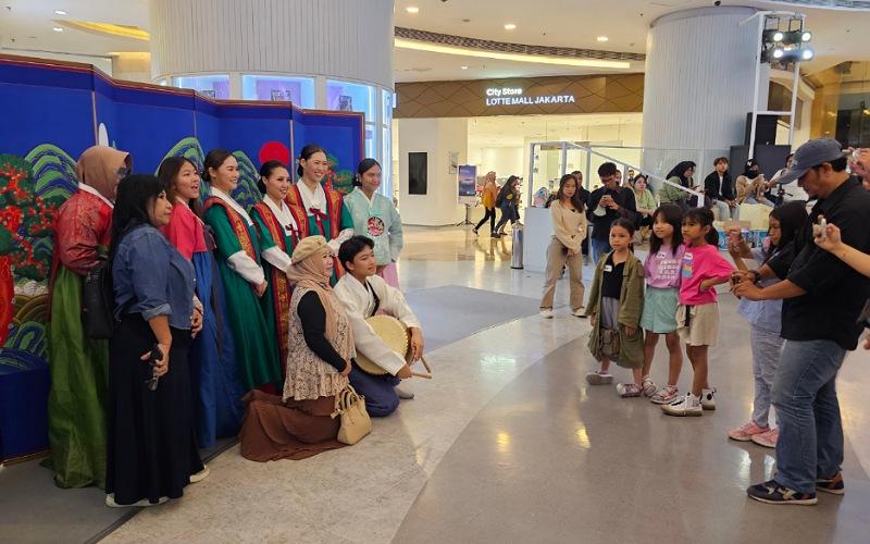 Pengunjung mal memakai hanbok dan berfoto dengan para pengisi acara Korean Cultural Night dengan latar belakang Irworobongdo. 