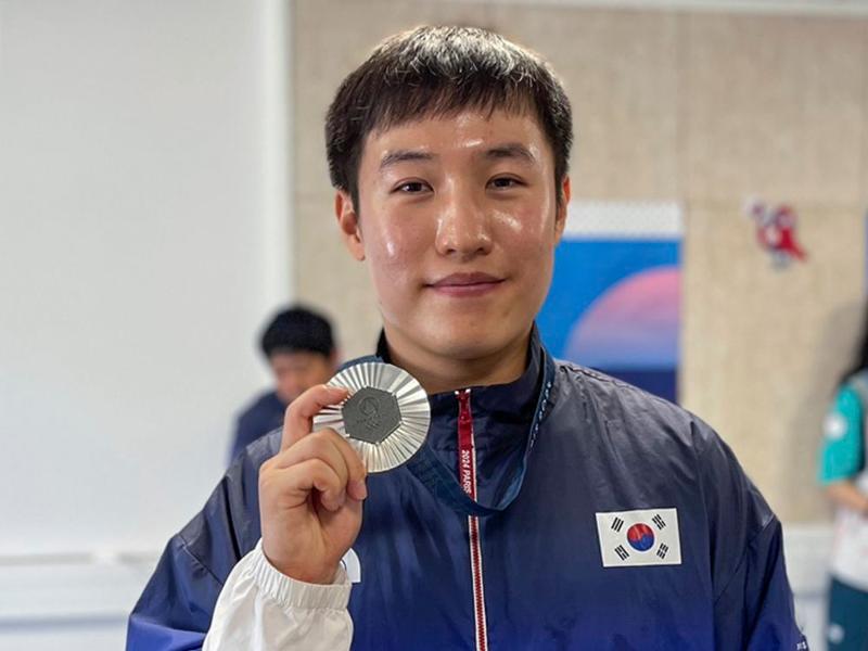 Cho Yeongjae terlihat sedang mengangkat medali setelah ia meraih medali perak dalam final 25m rapid fire pistol putra pada tanggal 5 Agustus (waktu setempat) di Pusat Menembak Chateauroux, Prancis.