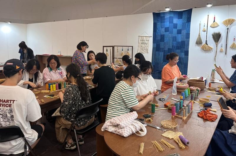 Para pengunjung terlihat sedang membuat sapu tradisional Korea yang menjadi bagian dari Hanbok Expo pada tanggal 9 Agustus 2024 di Dongdaemun Design Plaza, Seoul. (Israa Mohamed)