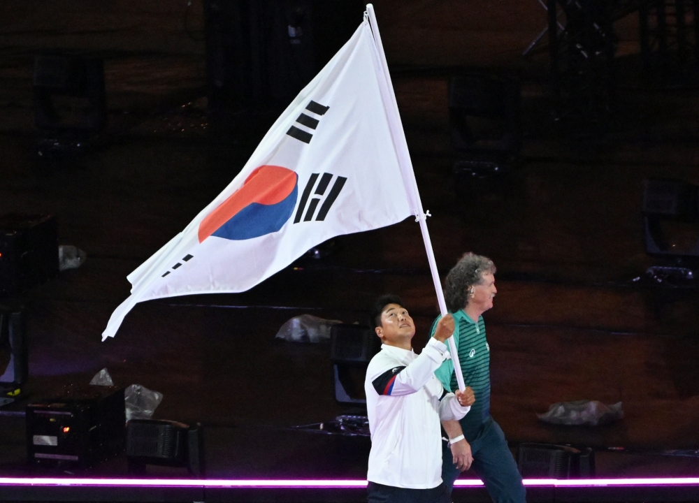 Atlet tim nasional Korea untuk Paralimpiade Paris 2024 Choi Yong Beom terlihat sedang masuk ke upacara penutupan sambil memegang taegeukgi (bendera nasional Korea). Upacara penutupan Paralimpiade Paris 2024 digelar pada tanggal 8 September 2024 (waktu setempat) di Stade de France, Saint-Denis, Paris, Prancis. 