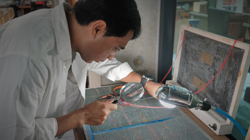 Penulis menggunakan lup untuk mencari logam karakter hangeul dan hanja. 