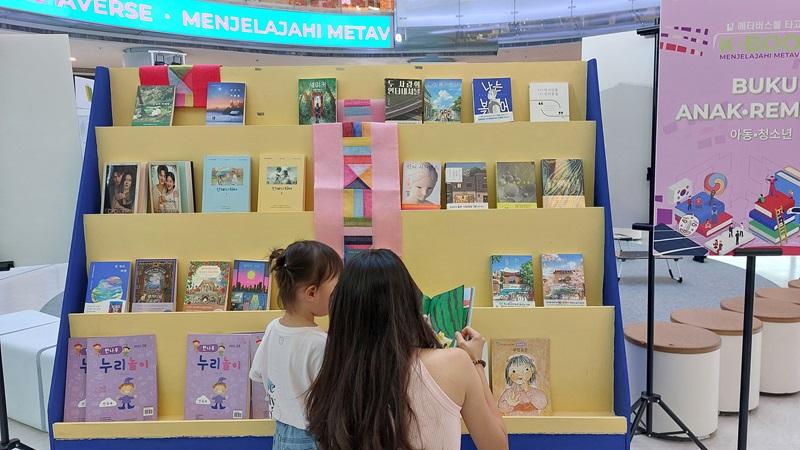 Potret pengunjung yang menikmati membaca buku di zona Buku Anak – Remaja. 