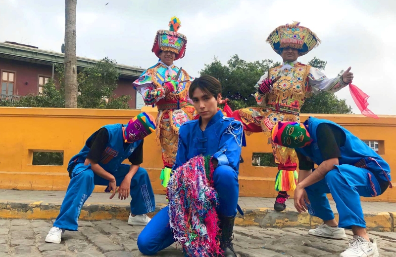 Lenin Tamayo terlihat sedang berfoto dengan para penari yang mengenakan topeng dan pakaian tradisional Peru.