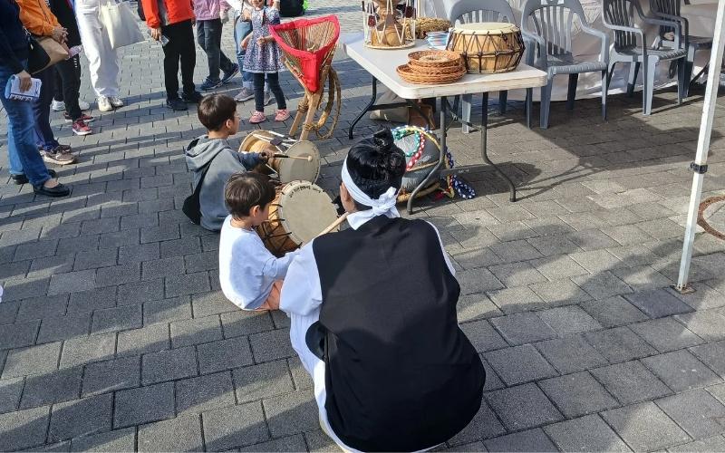 Seorang anak kecil memainkan janggu (gendang tradisional Korea) diiringi drum kecil pengiring janggu oleh adiknya di sebuah stan milik Museum Seni Rakyat Gudeok. 