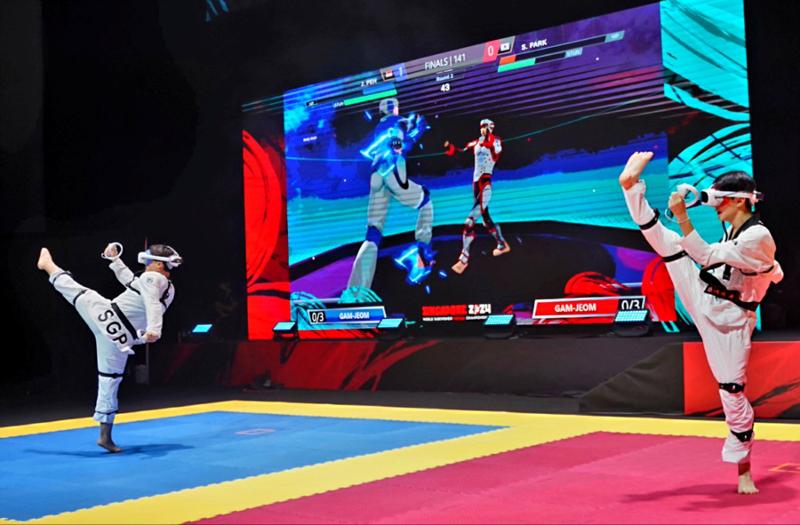 Park Seongbin (kanan) terlihat bertarung melawan Justin Peh dalam babak final Kejuaraan Taekwondo Virtual Dunia nomor perorangan  putra usia 16-35 tahun yang digelar pada tanggal 17 November 2024 (waktu setempat) di OCBC Arena, Singapore Sports Hub, Singapura. (World Taekwondo) 