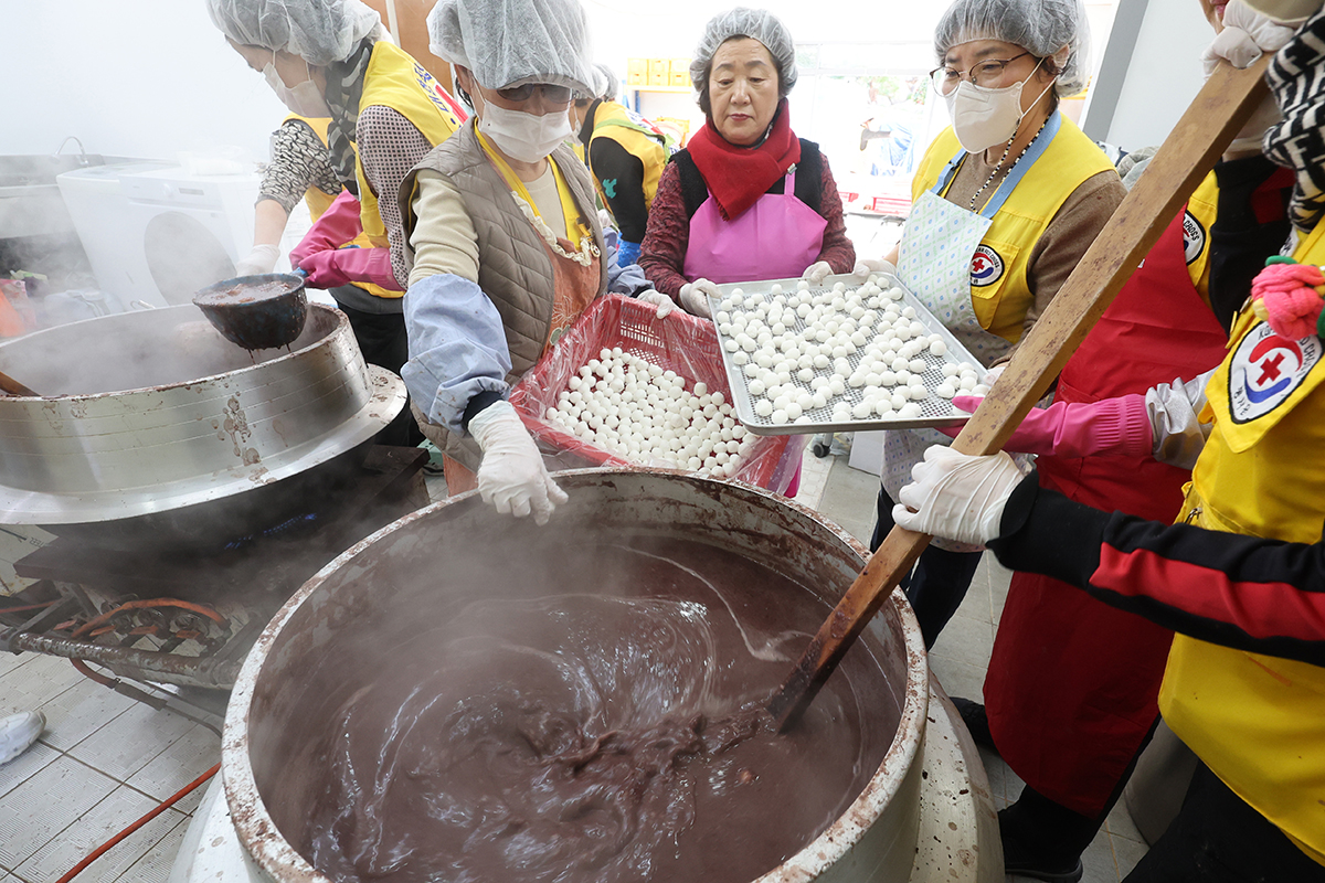 Para sukarelawan yang tergabung dalam Palang Merah Korea cabang Busan terlihat sedang membuat bubur kacang merah pada tanggal 19 Desember 2024. Para relawan membuat 600 porsi bubur kacang merah untuk dibagikan kepada 300 keluarga yang terdiri dari lansia dan kelompok rentan. Dongji tahun ini jatuh pada tanggal 21 Desember 2024. Dongji adalah hari titik balik matahari musim dingin. Hari ini adalah hari dengan waktu siang terpendek dan malam terpanjang dalam satu tahun. Di Korea, dipercaya bahwa membuat bubur kacang merah pada hari Dongji dan menyemburnya di gerbang atau jangdokdae akan mengusir hantu dan menghindari bencana. (Yonhap News)