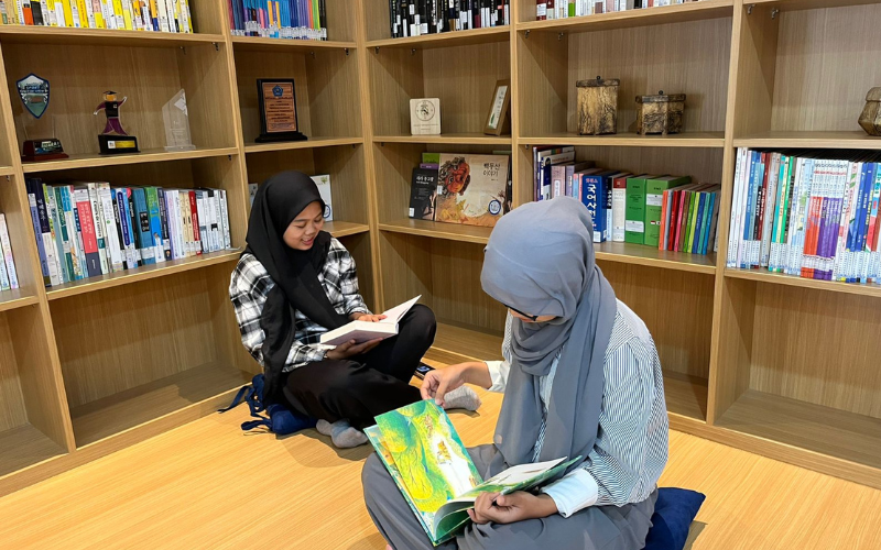 Beberapa mahasiswa Prodi Pendidikan Bahasa Korea membaca buku hibah dari Dinas Pendidikan Provinsi Jeju di Korean Corner FPBS UPI.