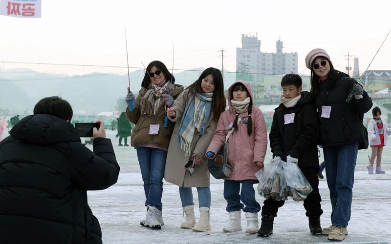 Para pengunjung asing terlihat sedang berfoto di Festival Hwacheon Sancheoneo yang digelar pada tanggal 14 Januari 2025 di Sungai Hwacheon, Hwacheon-gun, Provinsi Gangwon.