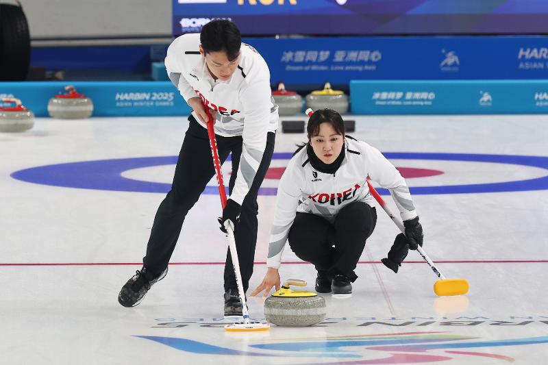 Tim curling ganda campuran Korea (Kim Kyeongae dan Seong Ji Hoon) berhasil meraih dua kemenangan setelah kalah di pertandingan pertama babak penyisihan. Foto di atas menunjukkan Kim dan Seong saat bertanding melawan Filipina dalam babak penyisihan Grup B yang digelar pada tanggal 4 Februari 2025 di Harbin Pingfang District Curling Arena, Harbin, Tiongkok. (Yonhap News)