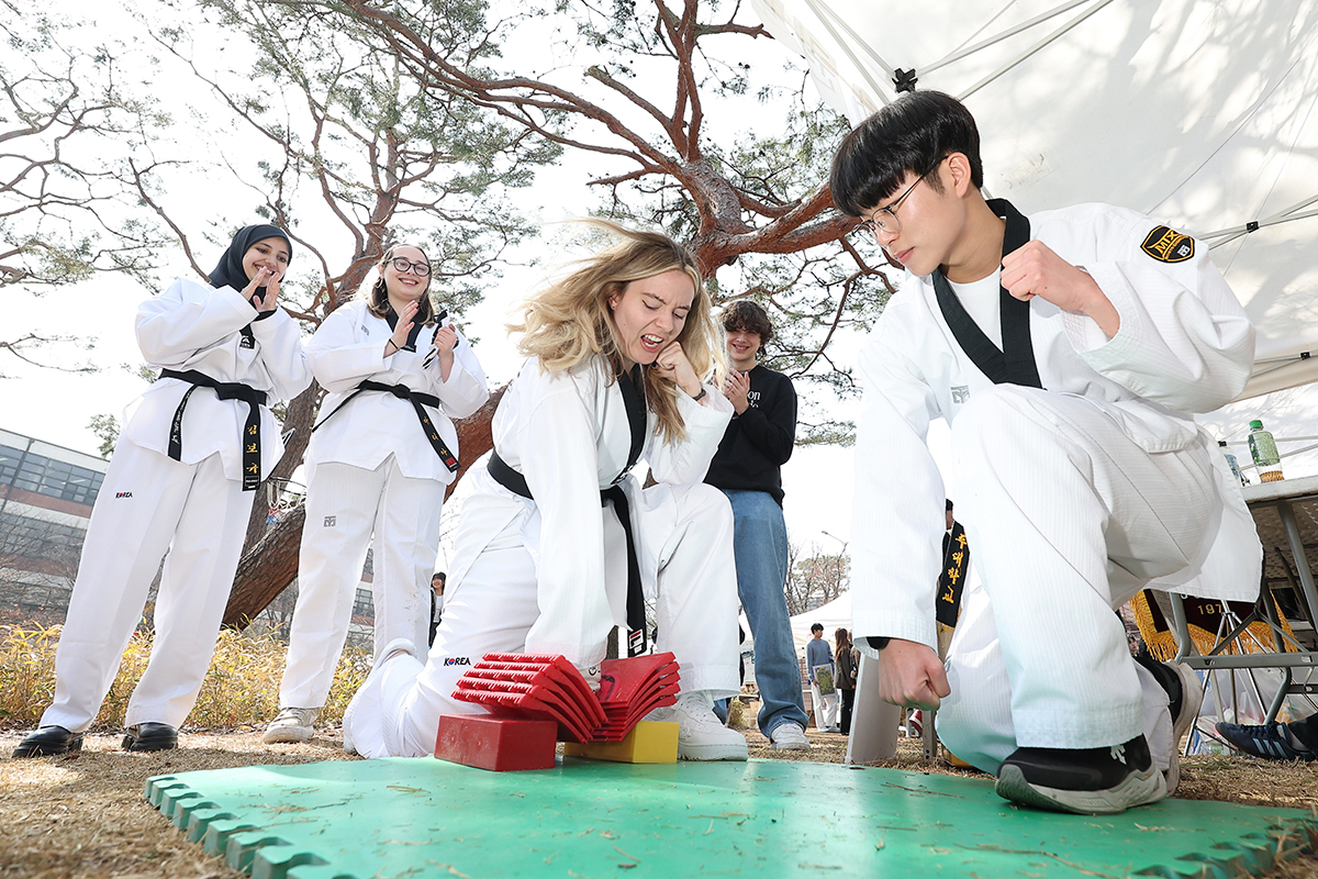 Para mahasiswa internasional terlihat sedang mencoba teknik kyukpa dalam taekwondo saat mengunjungi unit kegiatan mahasiswa (UKM) taekwondo dalam pameran UKM yang digelar tanggal 11 Maret 2025 di Universitas Ajou, Kota Suwon, Provinsi Gyeonggi. Teknik kyukpa adalah sebuah teknik dasar dalam taekwondo, yaitu teknik pemecahan benda-benda keras. (Yonhap News)