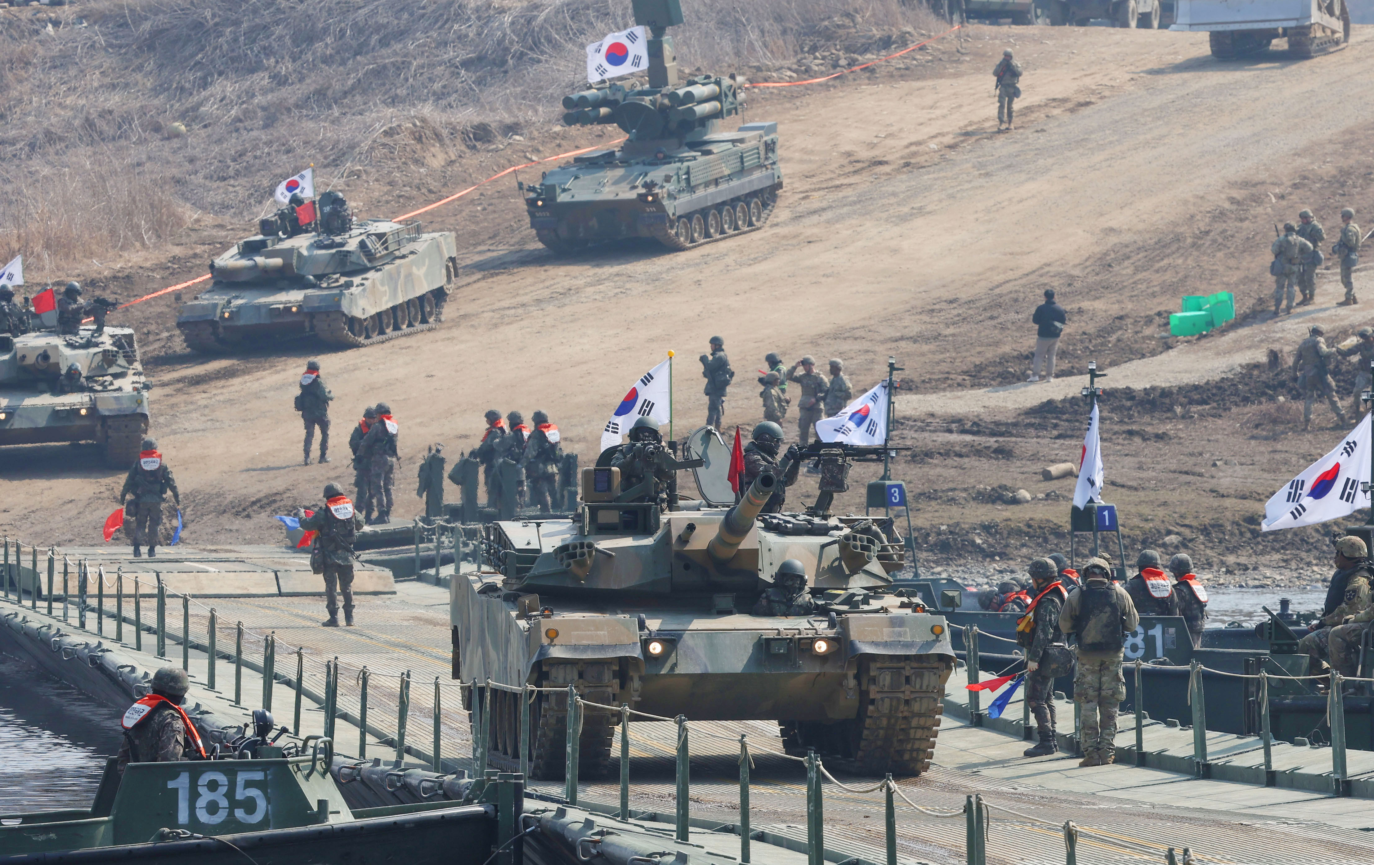 Sebuah tank K1E1 terlihat sedang bergerak di jembatan selama latihan penyeberangan sungai gabungan Korea-AS pada tanggal 20 Maret 2025 di tempat latihan Seogunso, Yeoncheon-gun, Provinsi Gyeonggi. Latihan tersebut dilaksanakan sebagai bagian dari latihan Freedom Shield 2025. Latihan Freedoom Shield 2025 merupakan latihan militer gabungan Korea-AS yang digelar dua kali setahun pada bulan Maret dan Agustus. (Defense Daily)