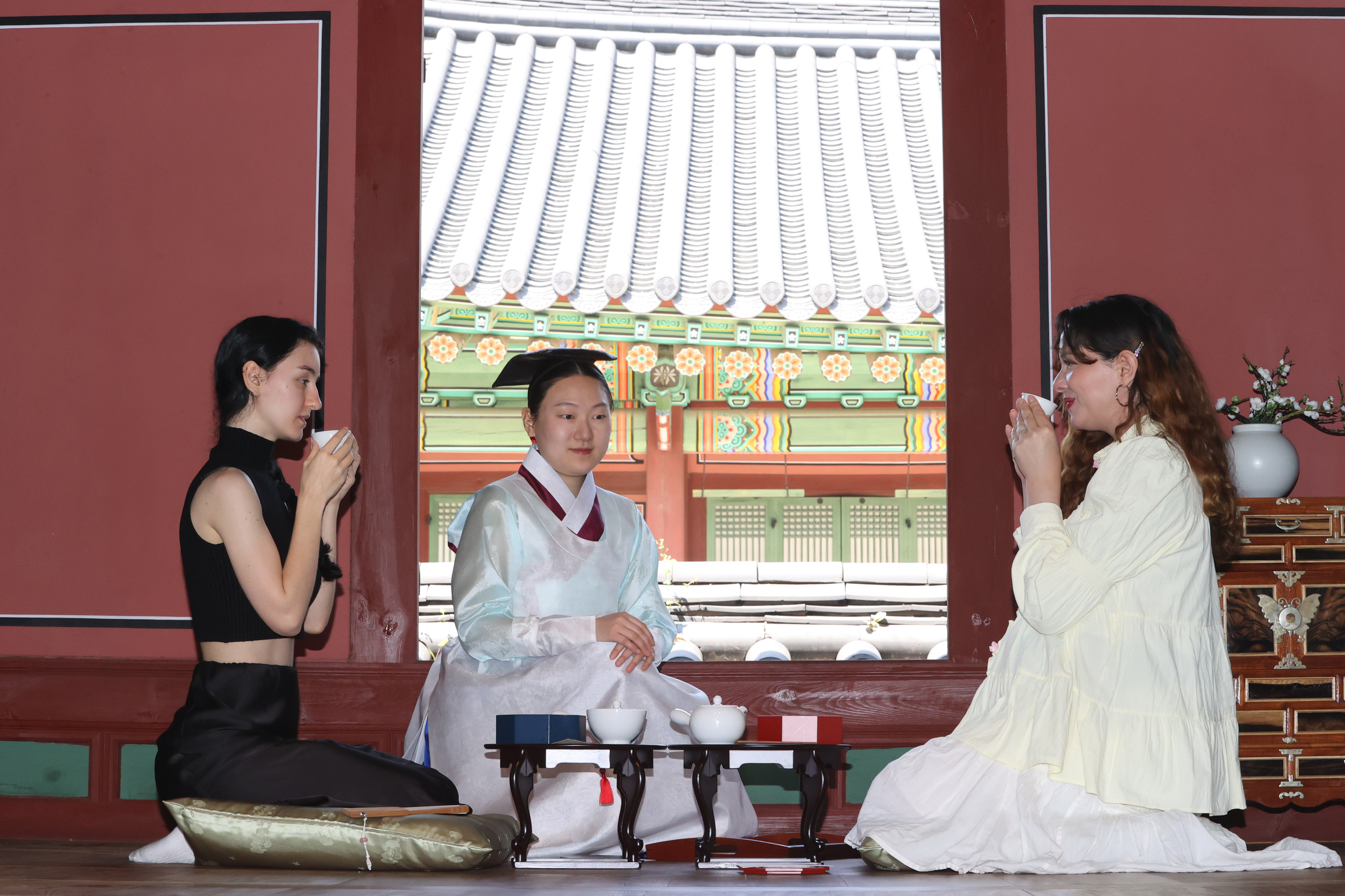 Dua orang wisatawan asing terlihat sedang mencicipi teh herbal dalam program yakdabang pada tanggal 12 Mei 2025 di Istana Changdeokgung, Jongno-gu, Seoul. Melalui program tersebut, peserta diajak untuk mencoba budaya tradisional istana Dinasti Joseon (1392-1910) melalui enam buah camilan manis istana dan teh herbal yang dibuat untuk menjaga kesehatan keluarga kerajaan. (Yonhap News)
