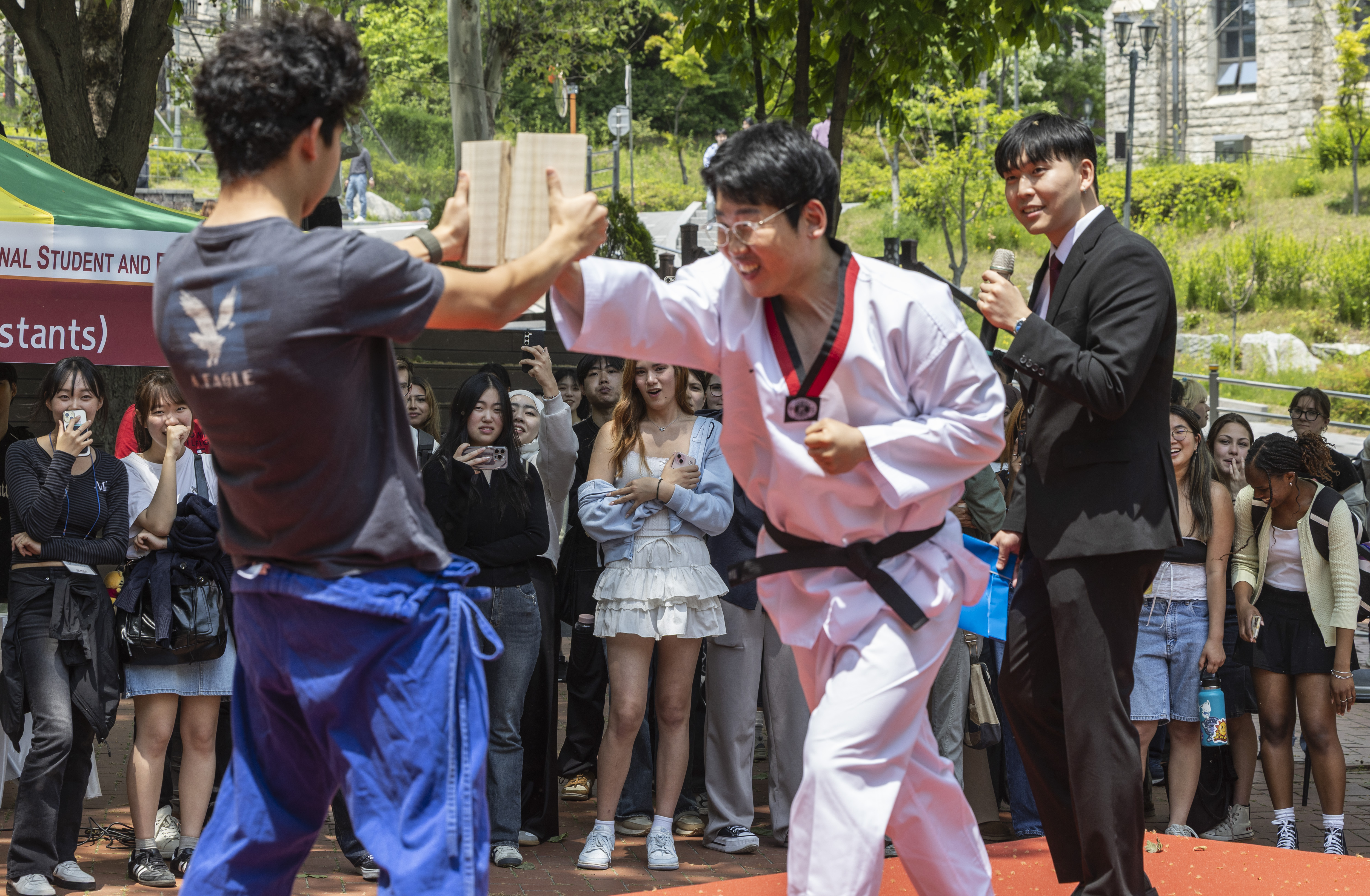 Demonstrasi teknik kyukpa diperlihatkan di depan para siswa internasional dalam Festival Mahasiswa dan Pegawai Fakultas Internasional yang digelar pada tanggal 13 Mei 2025 di Universitas Korea, Seongbuk-gu, Seoul. Teknik kyukpa adalah sebuah teknik dalam taekwondo untuk memecahkan benda keras, seperti papan, batu, dan bata. (Yonhap News)