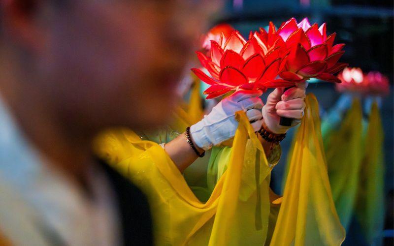 Lentera berbentuk bunga teratai bersinar di tengah parade Festival Lentera Teratai. 