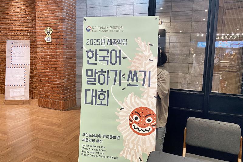 Poster Kontes Berbicara dan Menulis Bahasa Korea yang ditampilkan di CGV fX Sudirman sebagai lokasi pelaksanaan lomba pada tanggal 26 Mei 2025. 