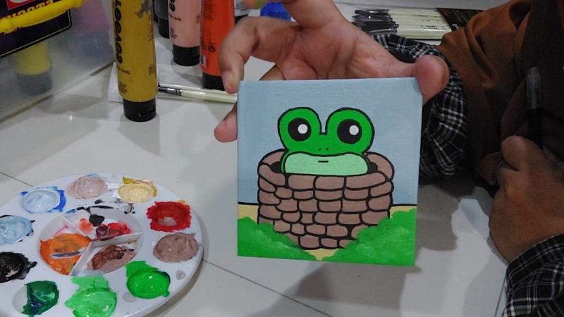 Penulis melukis peribahasa Korea katak dalam sumur ke atas kanvas kecil. (Maulia Resta Mardaningtias) 