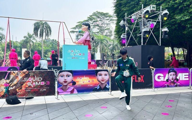 Seorang peserta berlatih jegichagi di depan arena Jump Rope Challenge sambil menunggu giliran bermain dan berfoto di photobooth berwarna biru muda. 