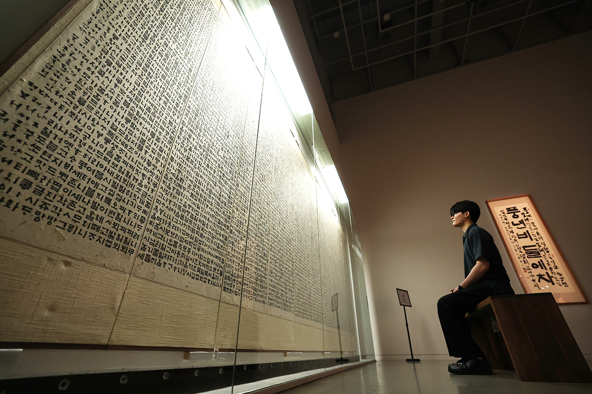   Seorang pengunjung terlihat sedang menikmati sebuah karya seni dalam pameran Selangkah Demi Selangkah: SeoHeehwan, Seorang Ahli Kaligrafi Hangeul. Foto tersebut diambil pada tanggal 18 Juli 2025 di Museum Seni Kaligrafi Seoul yang terletak di Seoul Arts Center, Seocho-gu, Seoul.     Pameran yang akan digelar hingga tanggal 21 Oktober 2025 tersebut menampilkan berbagai karya utama dari Seo Heehwan yang merupakan seniman kaligrafi hangeul pertama yang mendapatkan penghargaan presiden. (Lee Jeong Woo)