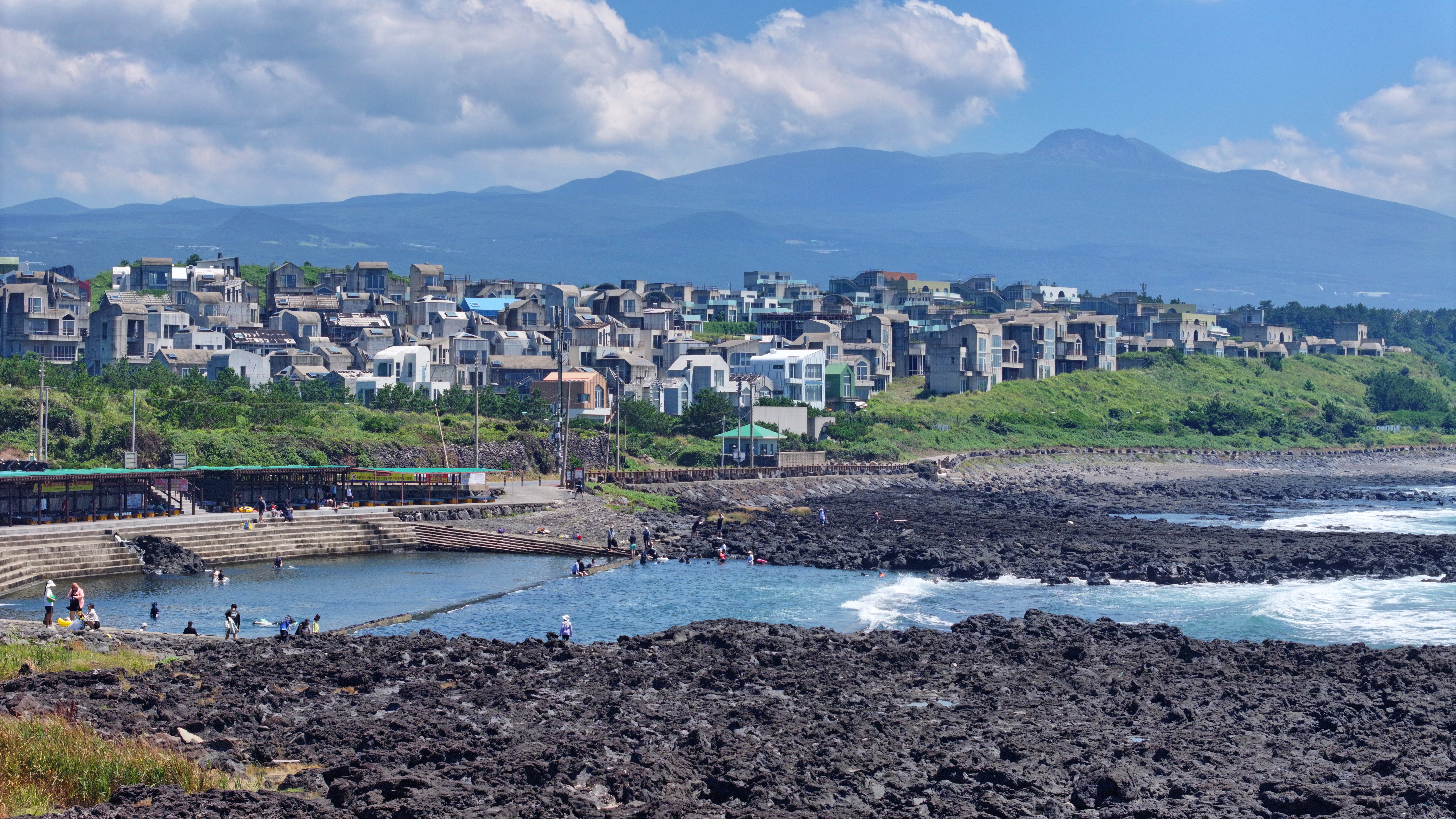 Pada pagi hari tanggal 24 Juli 2025, saat peringatan gelombang panas dikeluarkan, para pengunjung bermain air di Nonjitmul, Yerae-dong, Kota Seogwipo, Pulau Jeju. Nonjitmul adalah kolam air tawar yang terbentuk di tempat pertemuan antara mata air dan laut.