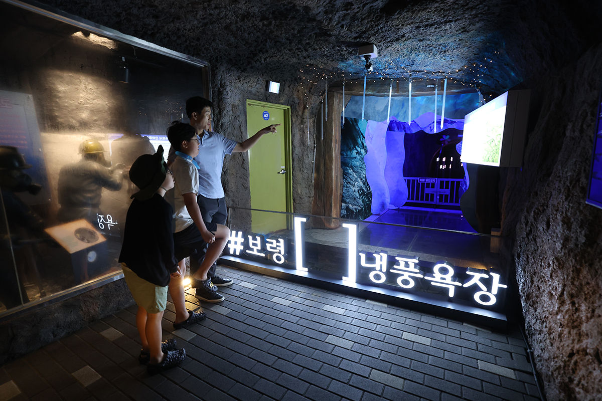 Pada tanggal 25 Juli 2025 sebuah keluarga terlihat sedang menikmati angin sejuk di Boryeong Spring Cool Tunnel & Rest Area yang dibangun di bekas lokasi tambang yang ditinggalkan di Boryeong, Provinsi Chungcheongnam. Destinasi wisata populer ini berfungsi sebagai pendingin udara alami dengan mempertahankan suhu antara 10 hingga 15 derajat Celsius sepanjang tahun. (Lee Jeong Woo)