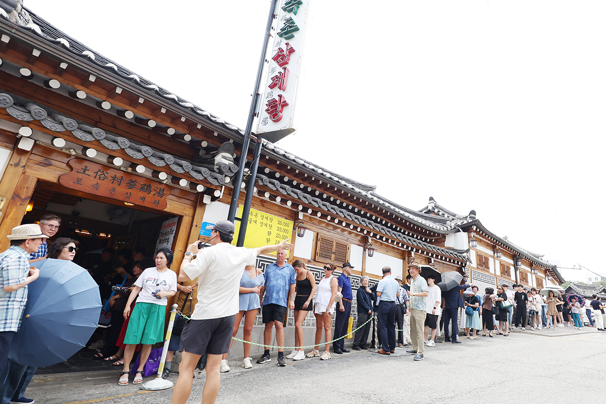 Antrean panjang terlihat mengular pada tanggal 30 Juli 2025 di depan sebuah restoran samgyetang yang terletak di Jongno-gu, Kota Seoul. Hari itu merupakan hari Jungbok, yaitu hari kedua di antara tiga hari terpanas yang berada di bulan keenam dan ketujuh menurut penanggalan lunar.     Masyarakat Korea biasanya memakan makanan yang dianggap bernutrisi pada hari Jungbok untuk membantu badan mereka supaya bisa pulih dari keletihan akibat cuaca yang panas. Salah satu menu terfavorit pada hari Jungbok adalah samgyetang, yaitu sup ayam ginseng. (Lee Jeong Woo)