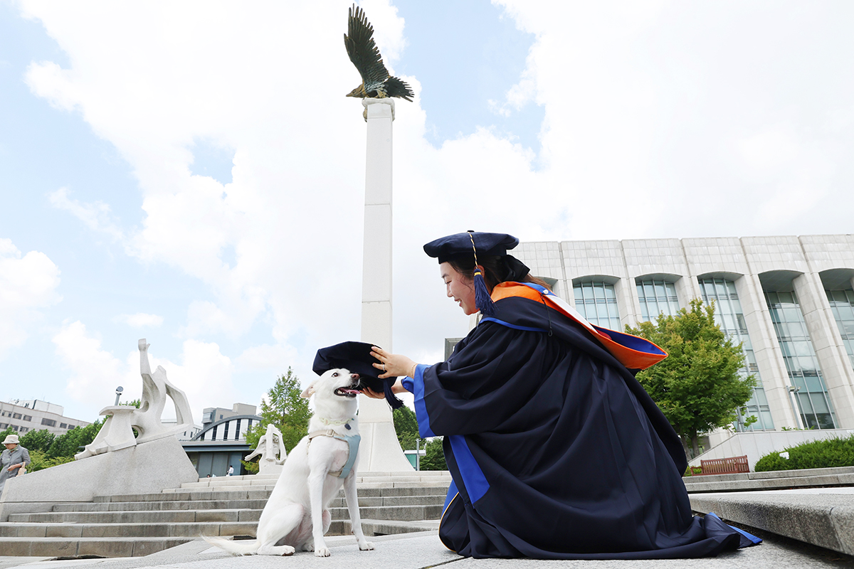 Seorang wisudawan terlihat sedang memasangkan topi wisudannya kepada anjing peliharaannya pada upacara wisuda yang digelar Universitas Yonsei yang terletak di Seodaemun-gu, Kota Seoul. 