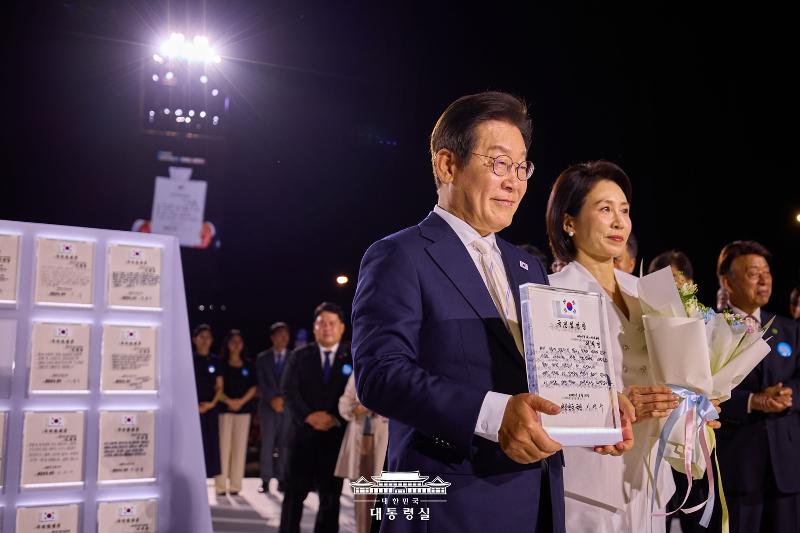 Presiden Lee Jae Myung dan Ibu Negara Kim Hea Kyung terlihat sedang memegang piagam Surat Mandat dari Rakyat yang ditulis oleh 80 orang perwakilan rakyat dalam Upacara Pelantikan Presiden oleh Rakyat yang digelar pada tanggal 15 Agustus 2025 di Alun-alun Gwanghwamun, Kota Seoul. (Kantor Kepresidenan Republik Korea)  