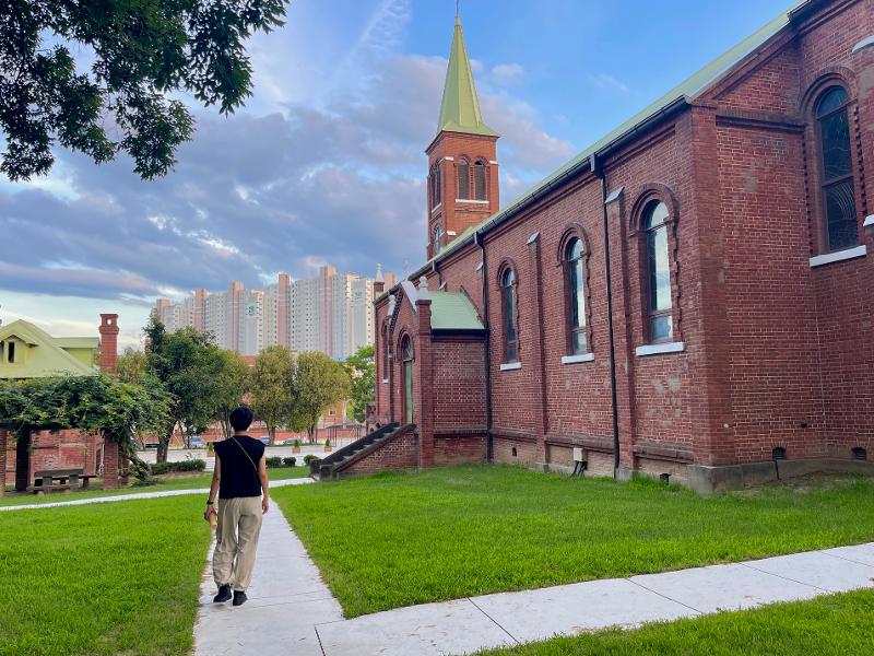 Seorang pemuda terlihat sedang berjalan di samping sebuah gereja tua yang berada di dalam Order of St. Benedict Waegwan Abbey, Chilgok-gun, Provinsi Gyeongsangbuk. 