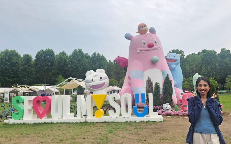 Penulis berfoto dengan boneka Haechi berukuran besar di tengah-tengah Taman Boramae.  