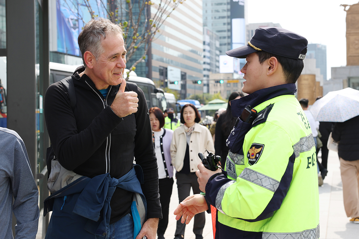 Seorang wisatawan asing terlihat mengacungkan jempolnya kepada seorang polisi setelah menerima bantuan pada tanggal 21 Oktober 2025 di Alun-alun Gwanghwamun, Jongno-gu, Seoul. 21 Oktober diperingati sebagai Hari Polisi setiap tahunnya untuk menumbuhkan semangat pengabdian kepolisian serta menghormati jasa para polisi yang telah mengabdi untuk keamanan dan ketertiban masyarakat. (Lee Jeong Woo)