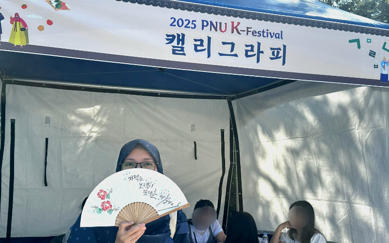 Penulis berfoto di salah satu stan 2025 PNU K-Festival. 