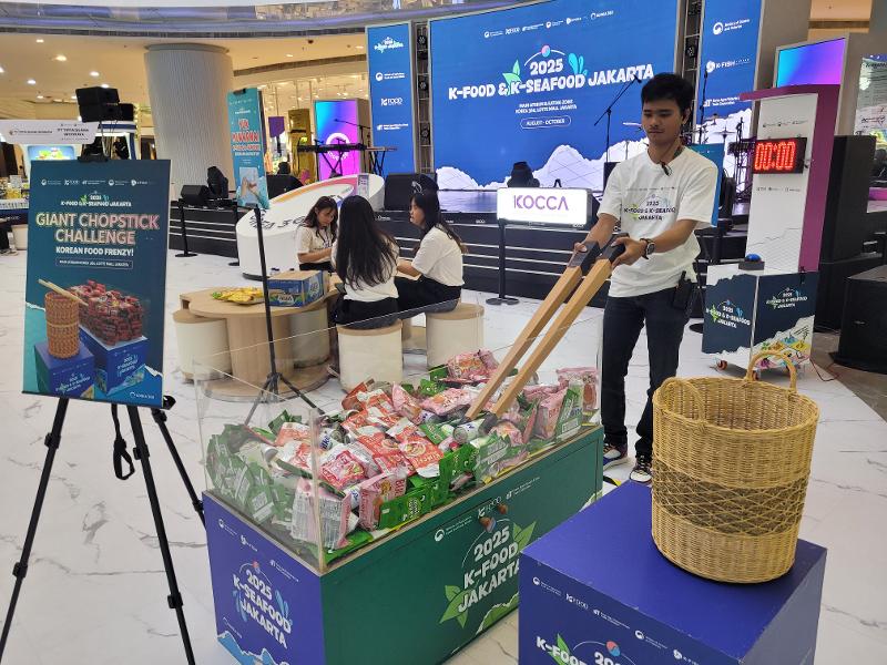 Salah satu permainan seru dalam acara K-Food & K-Seafood adalah tantangan mengambil produk makanan dan minuman dengan menggunakan sumpit besar. 
