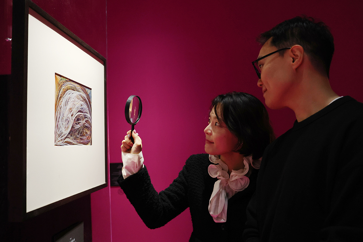 Seorang pengunjung terlihat sedang menggunakan kaca pembesar untuk mengamati karya seni dalam pameran Séance: Teknologi Jiwa di Seoul Museum of Art, Jung-gu, Seoul, pada tanggal 12 November 2025. Pameran yang merupakan bagian dari Seoul Mediacity Biennale ini mengeksplorasi hakikat jiwa manusia dan esensi seni dalam kehidupan kota modern. Pameran tersebut akan dibuka untuk umum hingga tanggal 23 November 2025. (Lee Jeong Woo) 