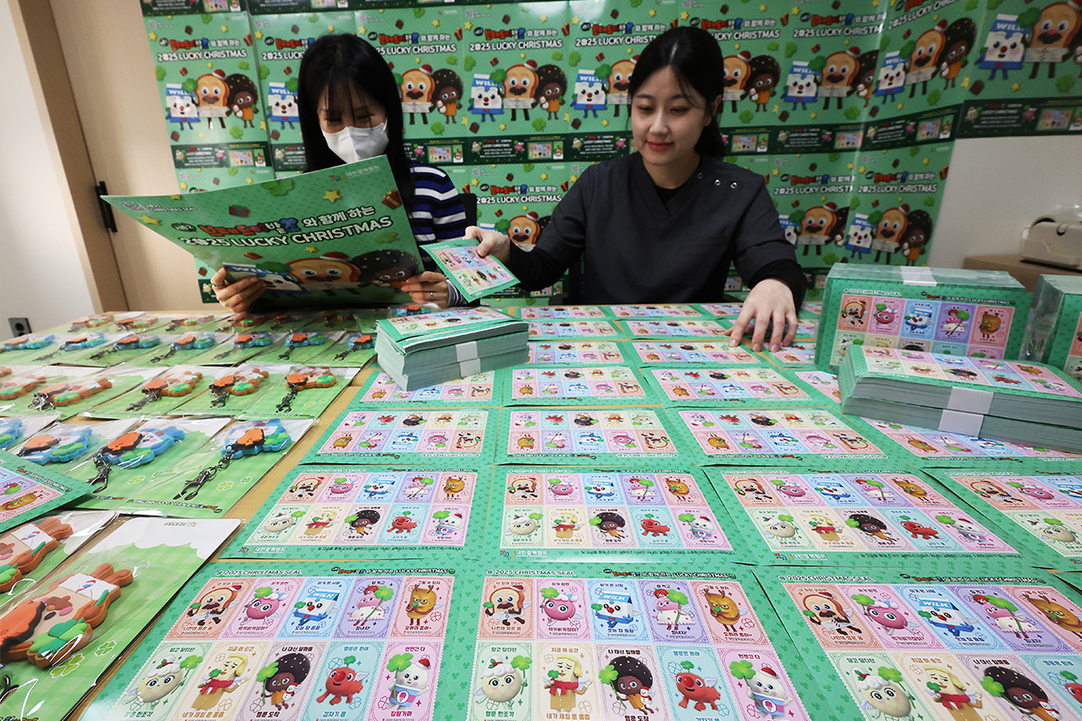  Para pegawai Asosiasi Tuberkulosis Nasional Korea cabang Provinsi Gyeonggi terlihat sedang memperlihatkan prangko natal tahun 2025 pada tanggal 24 November 2025 di kantor mereka yang terletak di Paldal-gu, Kota Suwon, Provinsi Gyeonggi.    Asosiasi Tuberkulosis Nasional Korea menerbitkan prangko natal tahun 2025 melalui kerja sama dengan konten anak berjudul Bread Barbershop untuk mengumpulkan donasi bagi mereka yang membutuhkan. (Yonhap News)