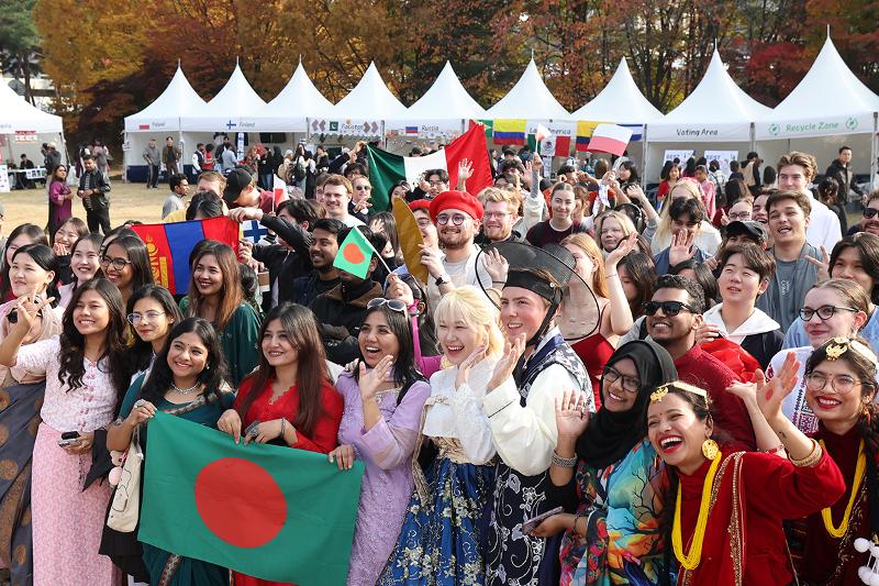 Mahasiswa internasional yang berpartisipasi dalam acara Ajou International Day ke-30 berkumpul sambil mengenakan pakaian tradisional dan mengabadikan momen bersama di lapangan rumput Universitas Ajou, Suwon, Provinsi Gyeonggi, pada tanggal 6 November 2025. Acara ini merupakan festival global yang memberikan kesempatan bagi mahasiswa internasional untuk memperkenalkan sejarah dan budaya negara mereka serta membangun pertukaran budaya. (Lee Jeong Woo) 