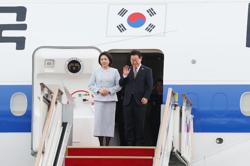 Presiden Lee Jae Myung dan Ibu Negara Kim Hea Kyung terlihat memberikan sapaan sebelum berangkat untuk kunjungan kenegaraan pada tanggal 17 November 2025 di pesawat Air Force One di Bandara Seoul, Seongnam, Provinsi Gyeonggi. (Lee Jeong Woo) 