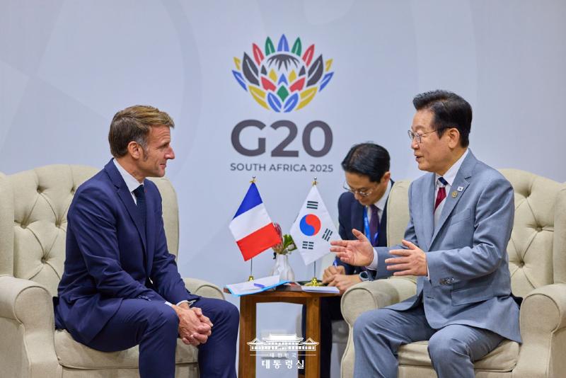 Presiden Lee Jae Myung (kanan) terlihat sedang menggelar pertemuan bilateral dengan Presiden Prancis, Emmanuel Macron, pada tanggal 22 November 2025 (waktu setempat) di Johannesburg Expo Center, Afrika Selatan.  