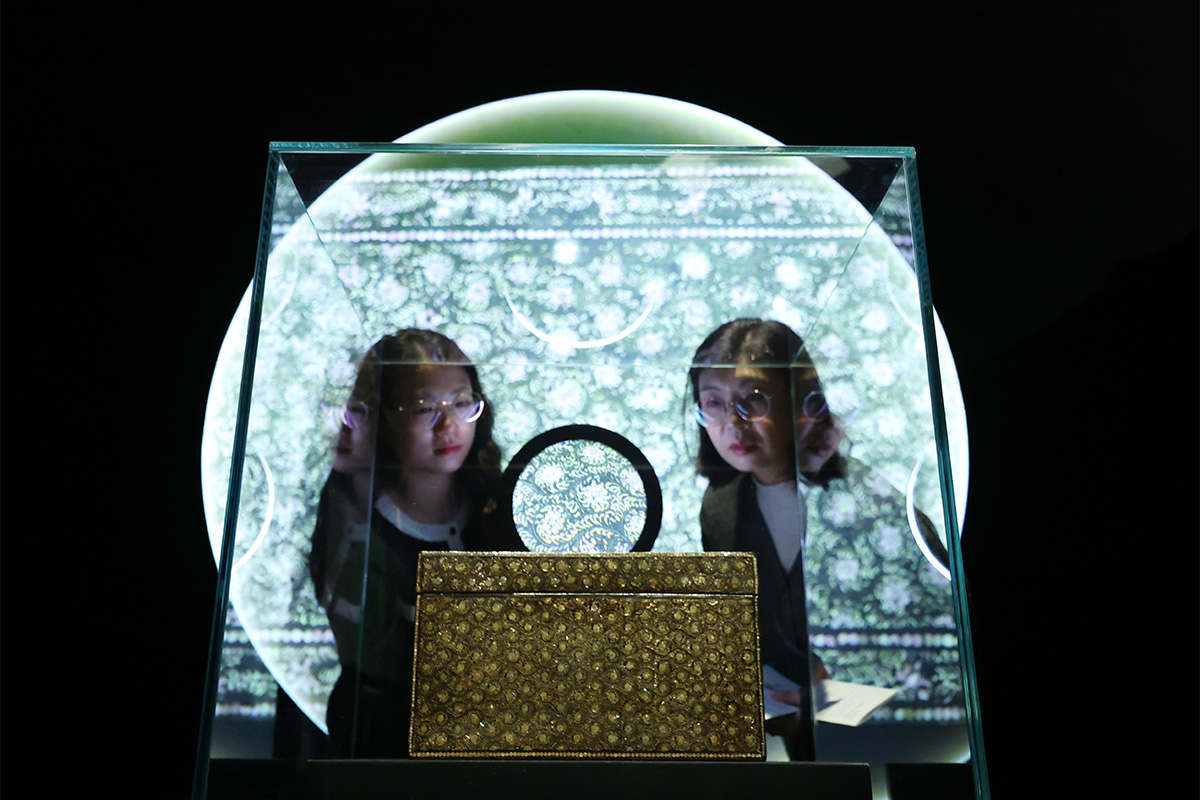 Dua orang warga terlihat sedang memperhatikan sebuah kotak berhias motif krisan dan mutiara serta gulungan yang dipamerkan dalam Pameran RE:BORN: Ilmu Pelestarian yang Menghubungkan Waktu pada tanggal 2 Desember 2025 di Museum Istana Nasional Korea, Jongno-gu, Kota Seoul.     Pameran tersebut digelar untuk memperingati 20 tahun pendirian Museum Istana Nasional Korea dan digelar hingga tanggal 1 Februari 2026. Pengunjung bisa melihat hasil dan proses pelestarian warisan budaya Korea secara ilmiah melalui pameran tersebut. (Yonhap News)