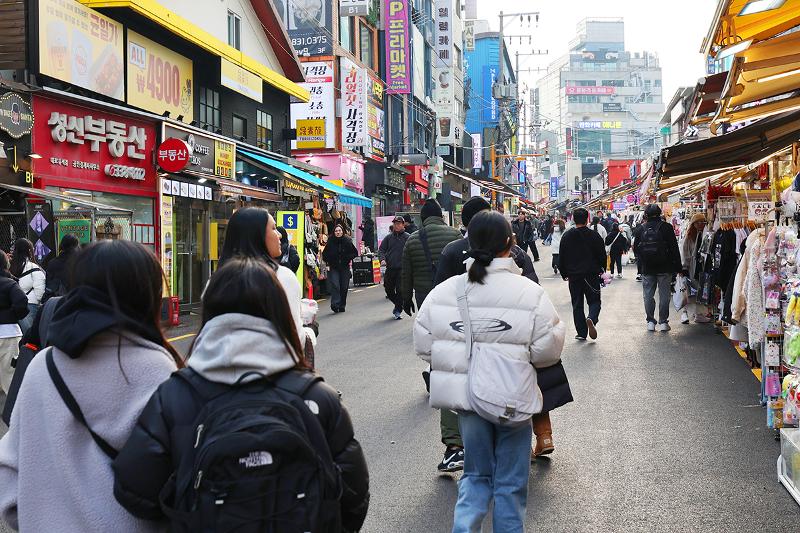 Para wisatawan terlihat memenuhi jalan Hongdae di Seoul pada tanggal 10 Desember 2025. Hongdae disebut sebagai ruang utama kaum muda di Korea untuk menampilkan ekspresi mereka. Wisatawan yang mengunjungi Hongdae bisa berbelanja di berbagai toko mode merek indi, menonton pertunjukan pemusik jalanan, dan mengunjungi toko pop-up dengan berbagai tema. Hongdae membuat para wisatawan mancanegara bisa merasakan langsung ekspresi kaum muda Korea. Selain itu, wisatawan asing juga bisa berbelanja sesuai dengan preferensi gayanya melalui berbagai merek pakaian terkenal yang membuka tokonya di Hongdae. 