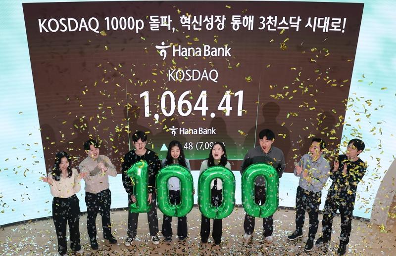Pada tanggal 26 Januari 2026, ketika indeks KOSDAQ melampaui level 1.000 untuk pertama kalinya dalam lebih dari empat tahun, para dealer berfoto bersama di ruang dealing kantor pusat Hana Bank di Jung-gu, Seoul. (Yonhap News)
