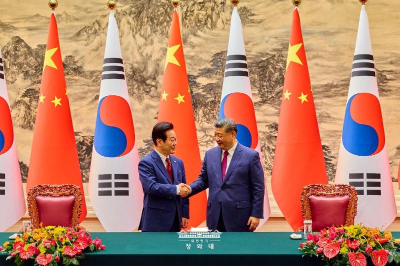 Presiden Lee Jae Myung (kiri) dan Presiden Tiongkok Xi Jinping terlihat sedang berjabat tangan dalam upacara penandatanganan nota kesepahaman (MoU) Korea–Tiongkok yang digelar pada tanggal 5 Januari 2026 di Balai Besar Rakyat, Beijing, Tiongkok. (Cheong Wa Dae)