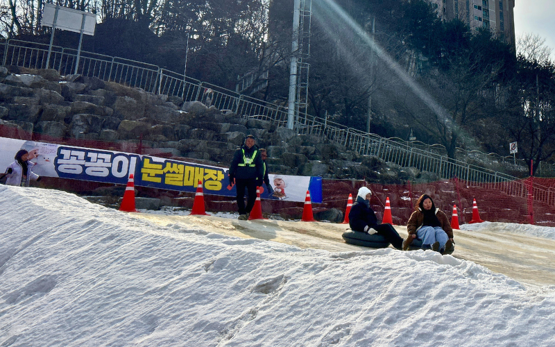 Pengunjung dari berbagai usia menikmati permainan musim dingin gratis, seperti seluncur salju dan bermain di sungai yang membeku.