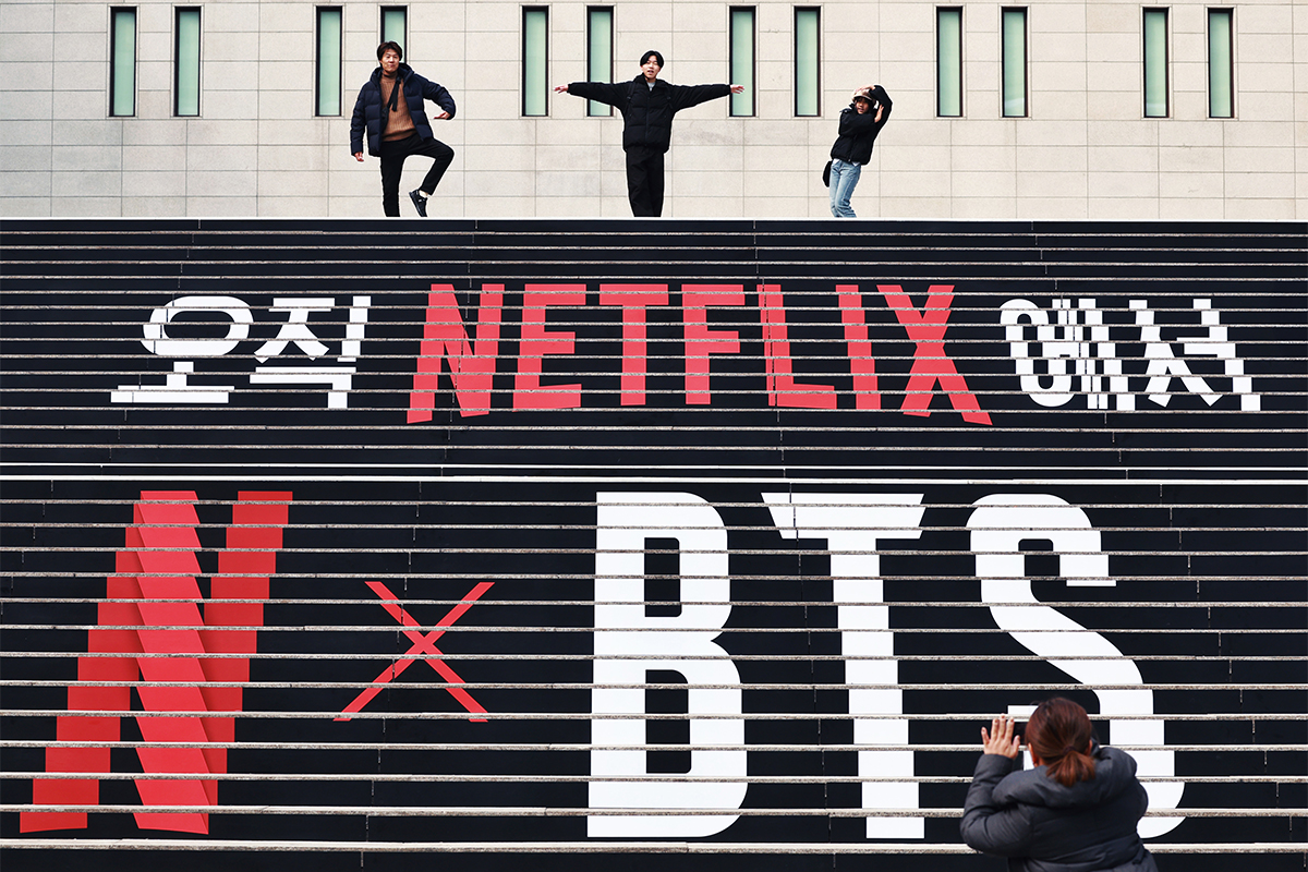 Pada tanggal 11 Maret 2026 para wisatawan mancanegara terlihat sedang berfoto di depan materi promosi konser BTS yang akan kembali tampil sebagai grup lengkap di tangga Sejong Center for the Performing Arts, Jongno-gu, Seoul. (Yonhap News)