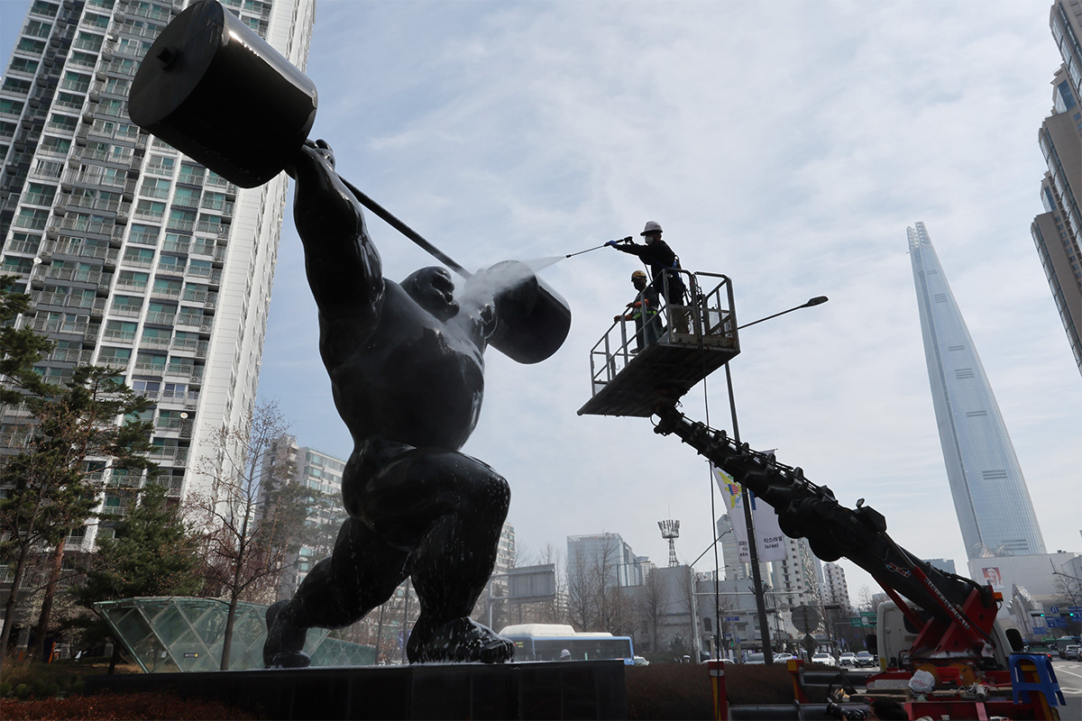 Pada tanggal 25 Maret 2026 para petugas melakukan pekerjaan pembersihan pada instalasi simbol Olimpiade di Jamsil-dong, Songpa-gu, Seoul. (Yonhap News)