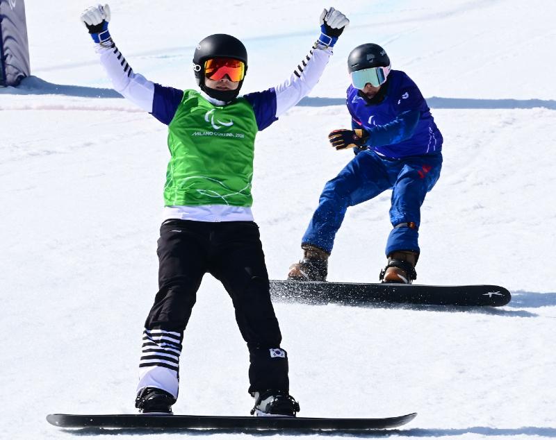 Lee Jehyuk (kiri) berhasil menempati posisi ketiga pada babak final para snowboard nomor cross SB-LL2 yang digelar pada tanggal 8 Maret 2026 (waktu setempat) di Cortina Para Snowboard Park, Italia.