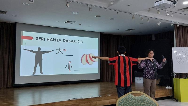 Pemateri menjelaskan kepada para peserta bahwa penulisan huruf Hanja terinspirasi dari benda nyata. 