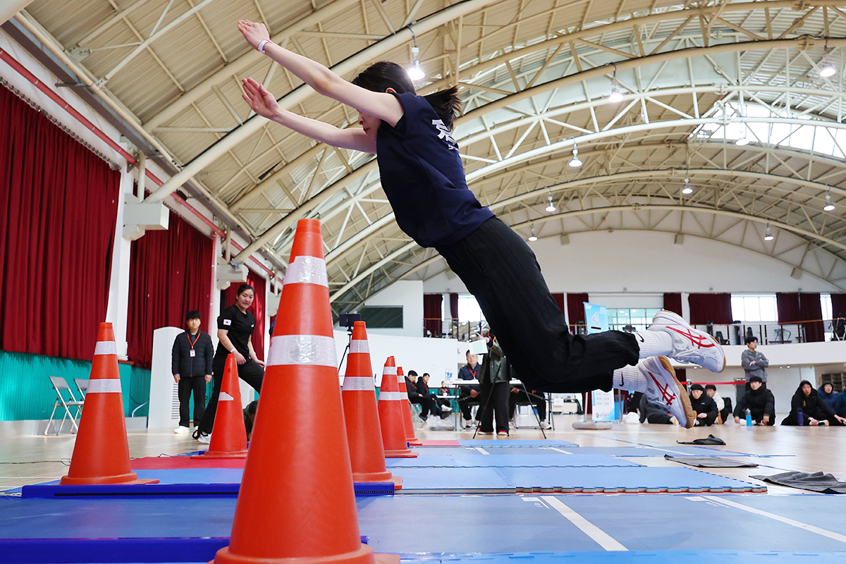 Seorang peserta terlihat sedang melakukan lompat jauh tanpa awalan dalam Tes Fisik Penerimaan Calon Pemadam Kebakaran 2026 yang digelar di aula Institut Pengembangan Sumber Daya Manusia Incheon, Seo-gu, Incheon, pada tanggal 1 April 2026. (Yonhap News)