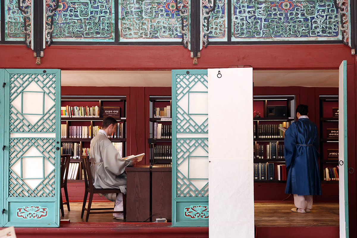 Dua orang wisatawan asing terlihat sedang membaca buku di Jibokjae, Istana Gyeongbokgung, Seoul, pada tanggal 9 April 2026. Bangunan yang dahulu merupakan perpustakaan pribadi Raja Gojong ini kini menjadi perpustakaan kecil dan dibuka bagi pengunjung hingga tanggal 31 Oktober 2026. (Lee Jeong Woo)