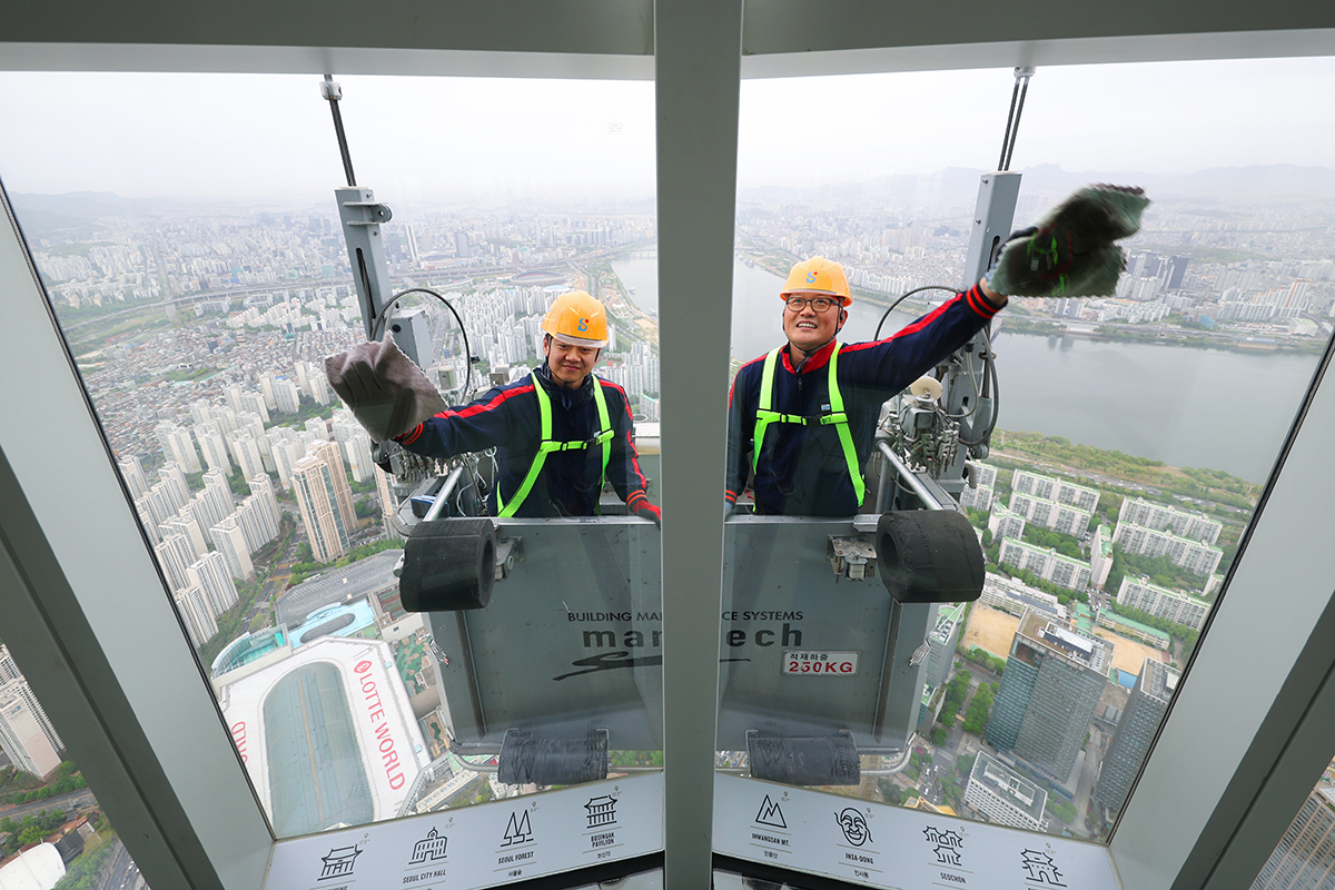 Para petugas terlihat sedang membersihkan fasad gedung Seoul Sky di Lotte World Tower, Songpa-gu, Seoul, pada tanggal 22 April 2026, untuk menyambut musim semi. (Lee Jeong Woo)