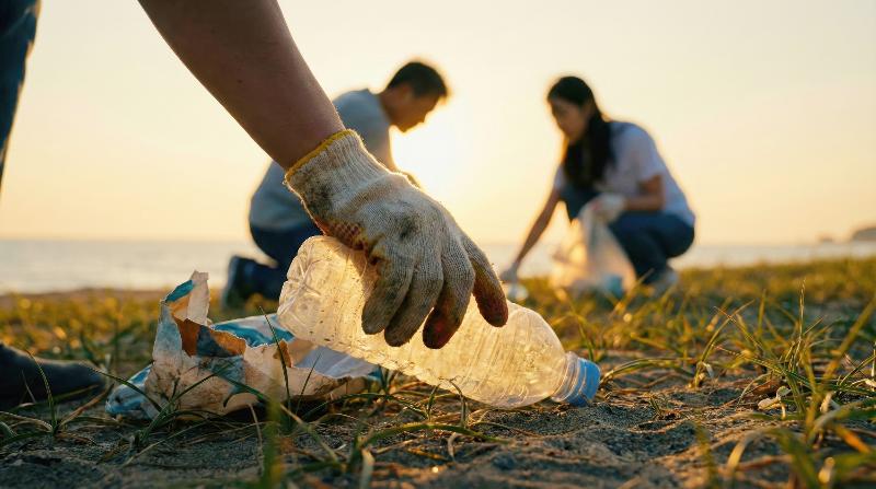 Para warga terlihat sedang memungut limbah plastik di pantai dalam kegiatan bersih-bersih lingkungan. (iClick Art) *Reproduksi dan pendistribusian ulang foto di atas secara tidak sah dilarang berdasarkan undang-undang hak cipta.